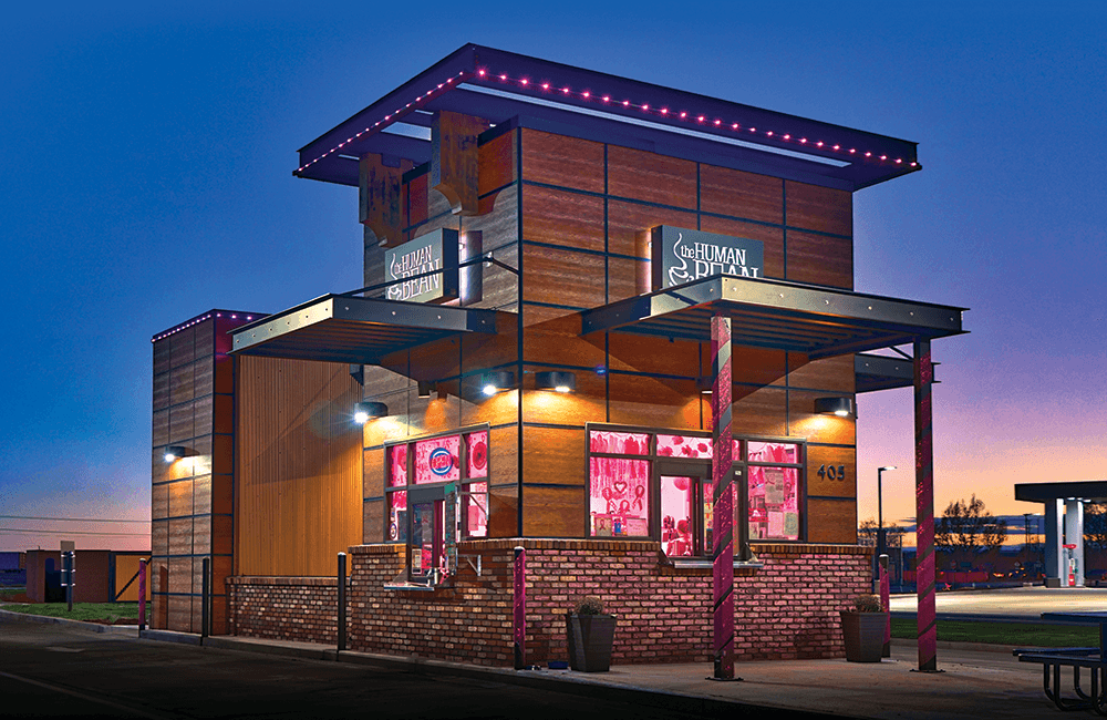 Commercial drive-thru building with warm permanent roofline lighting